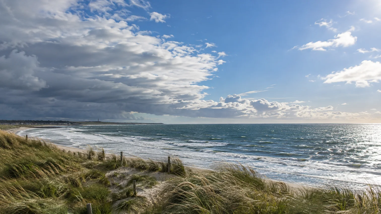 North Sea or Channel coast with brighter sky to the east and an Atlantic cloud band approaching from the west.