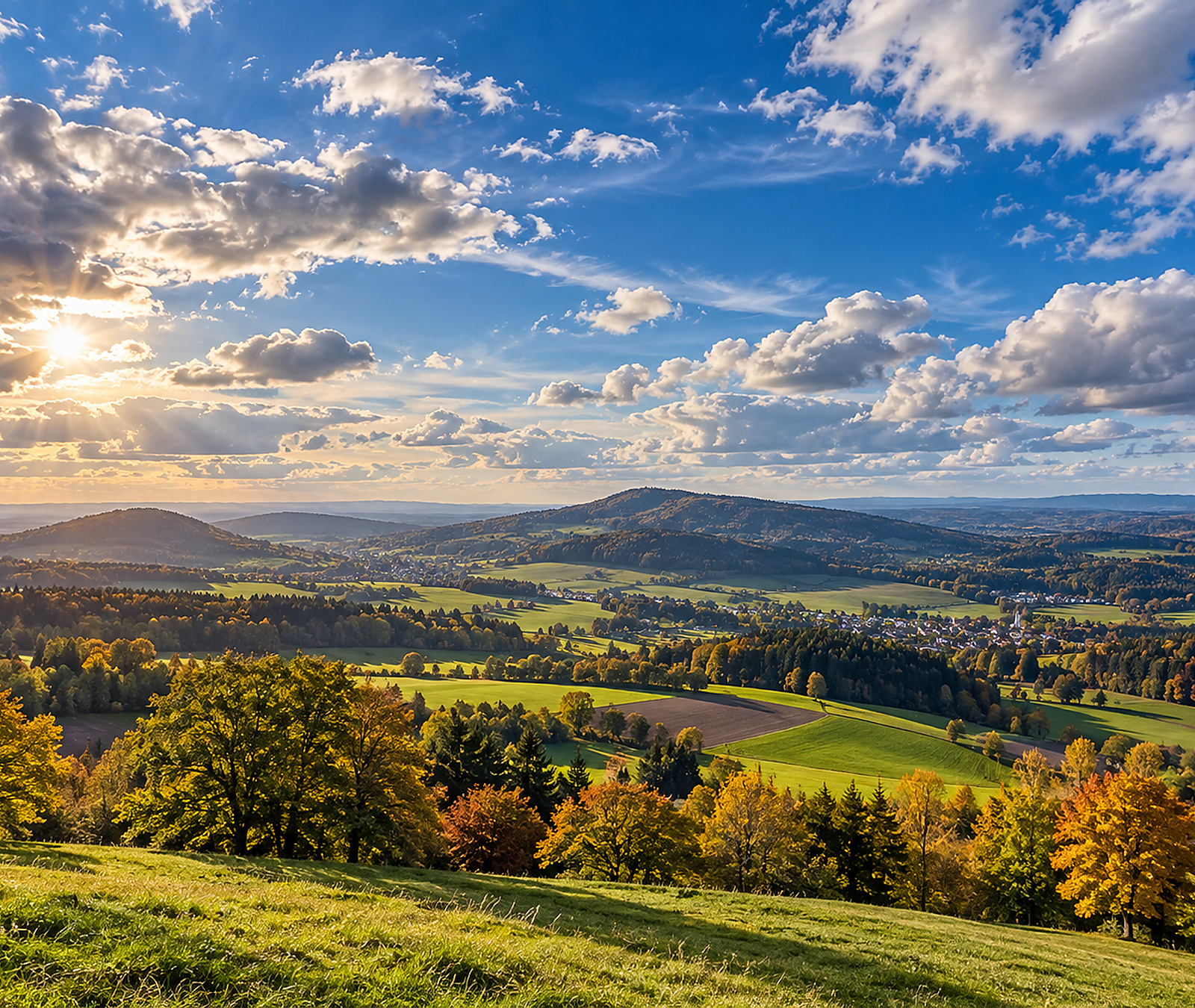 Wide European autumn landscape with sunshine, clouds and rolling countryside