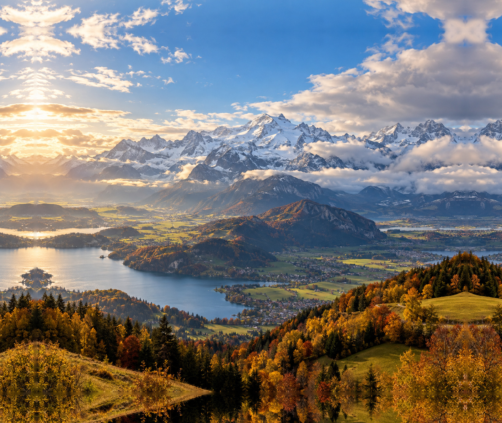 European autumn weather scene with Alpine peaks, cloud breaks, sunshine and varied conditions across the valleys
