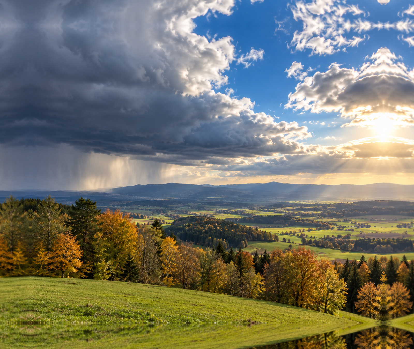 European autumn landscape beneath mixed sunshine and a distant rain shaft, illustrating the divided weather pattern through Tuesday evening.