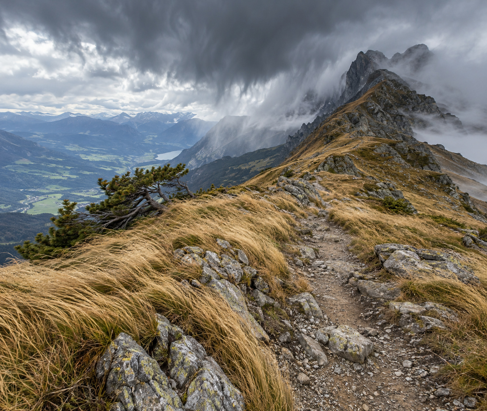 Windblown ridge beneath dark clouds; illustrative mountain-weather photo, not an actual weather report